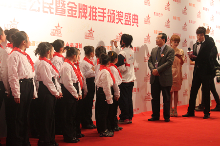 南都公益基金会理事长徐永光和新公民学校的孩子走红地毯